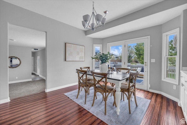 dining area featuring baseboards, a chandelier, and dark wood finished floors