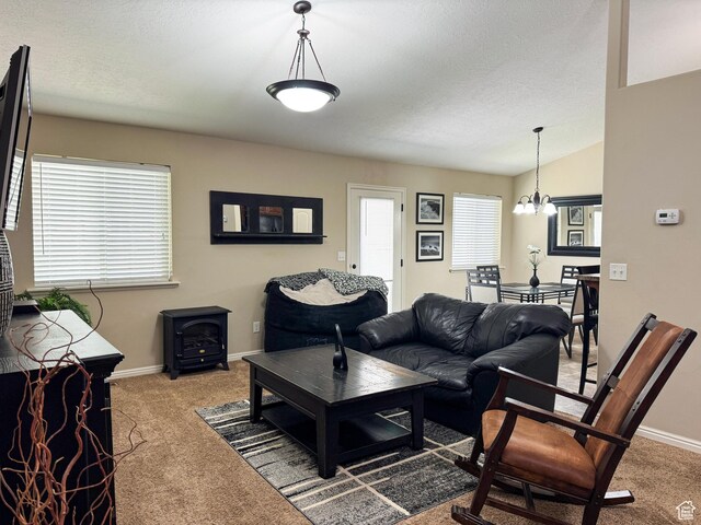 1661 S 1960 E, Spanish Fork, UT 84660 - living area featuring light carpet, a wood stove, a chandelier, baseboards, and a textured ceiling