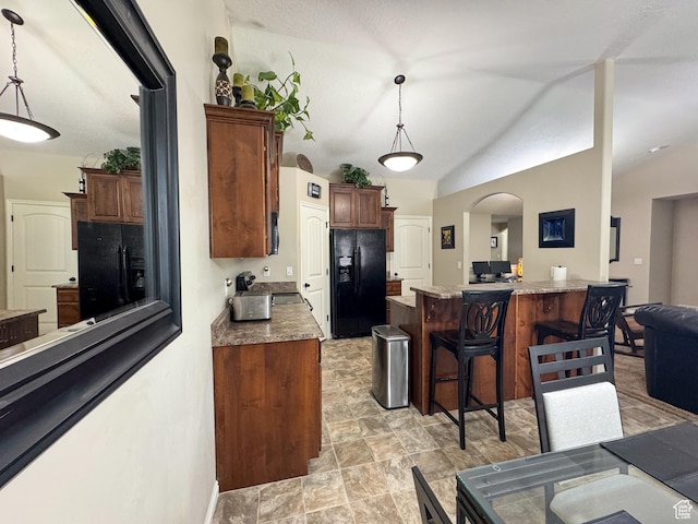 1661 S 1960 E, Spanish Fork, UT 84660 - kitchen featuring black fridge, a breakfast bar, arched walkways, pendant lighting, and lofted ceiling