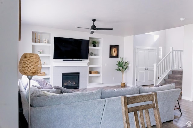 14944 S Beckham Dr W, Herriman, UT 84096 - living room featuring a ceiling fan, wood finished floors, stairs, a brick fireplace, and built in features