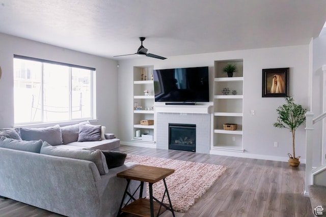 14944 S Beckham Dr W, Herriman, UT 84096 - living room featuring wood finished floors, a brick fireplace, baseboards, and ceiling fan