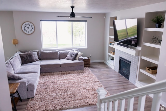 14944 S Beckham Dr W, Herriman, UT 84096 - living room with a ceiling fan, wood finished floors, a fireplace, baseboards, and built in features