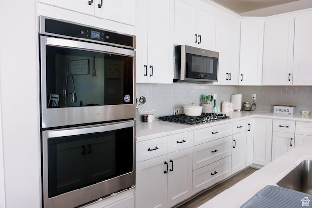 14944 S Beckham Dr W, Herriman, UT 84096 - kitchen featuring stainless steel appliances, light countertops, white cabinetry, and tasteful backsplash