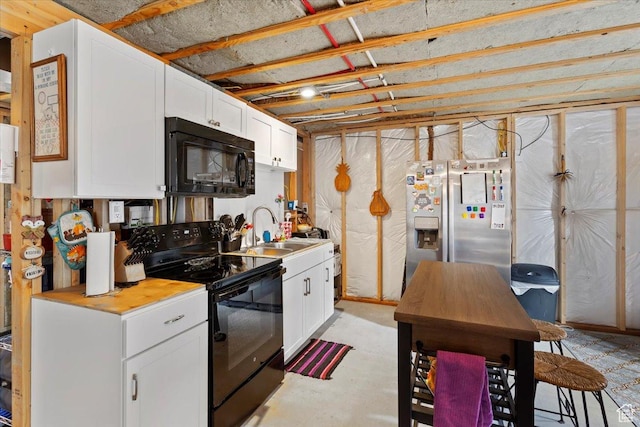 kitchen with black appliances, a sink, white cabinets, and light countertops