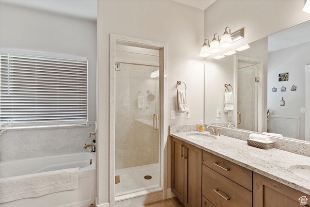 bathroom with a shower stall, a bath, and double vanity