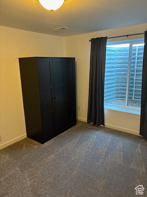 unfurnished bedroom with multiple windows, baseboards, and carpet flooring
