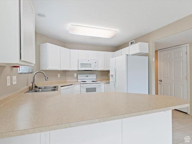 kitchen featuring white appliances, a sink, a peninsula, light countertops, and white cabinetry
