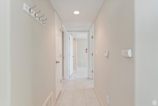 corridor with light tile patterned flooring and baseboards