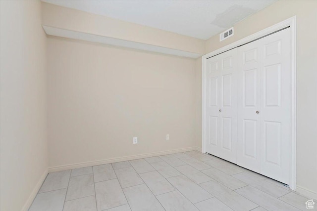 unfurnished bedroom featuring a closet and baseboards