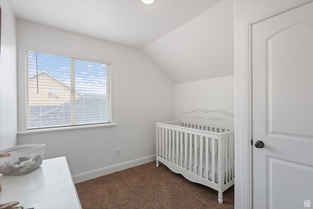 bedroom featuring vaulted ceiling, carpet, a crib, and baseboards