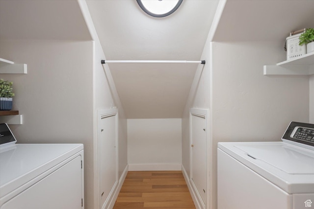 laundry room featuring washer and clothes dryer and light wood-style floors