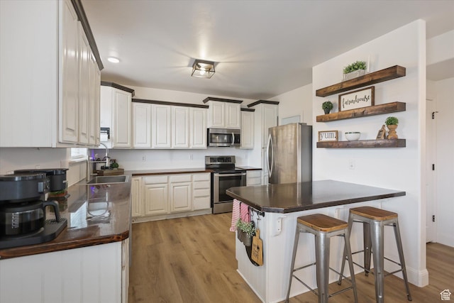 61 N Peach St, Santaquin, UT 84655 - kitchen featuring stainless steel appliances, open shelves, a sink, a kitchen breakfast bar, and dark countertops