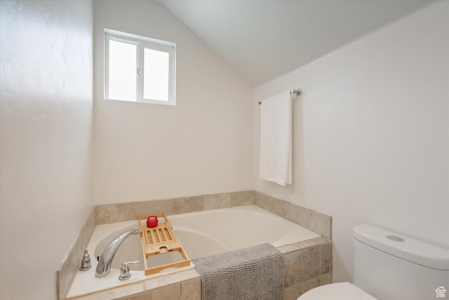 bathroom with toilet, lofted ceiling, and a bath