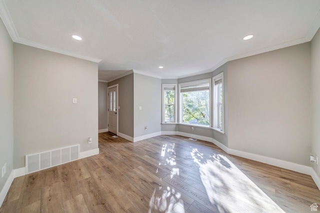 spare room with baseboards, wood finished floors, recessed lighting, and ornamental molding
