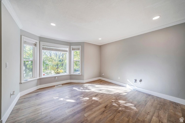 unfurnished room with crown molding, baseboards, wood finished floors, recessed lighting, and a textured ceiling