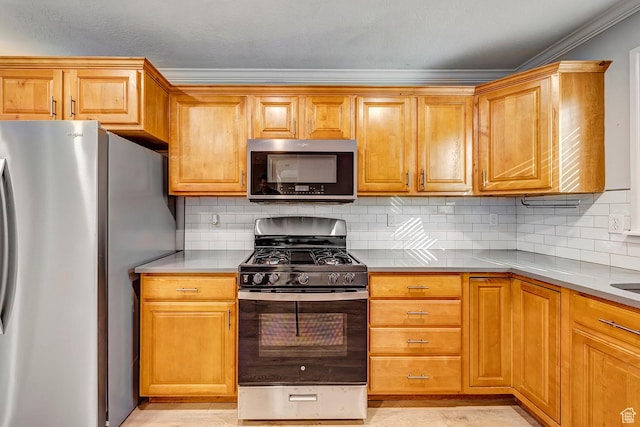 kitchen with stainless steel appliances, ornamental molding, light countertops, backsplash, and brown cabinets