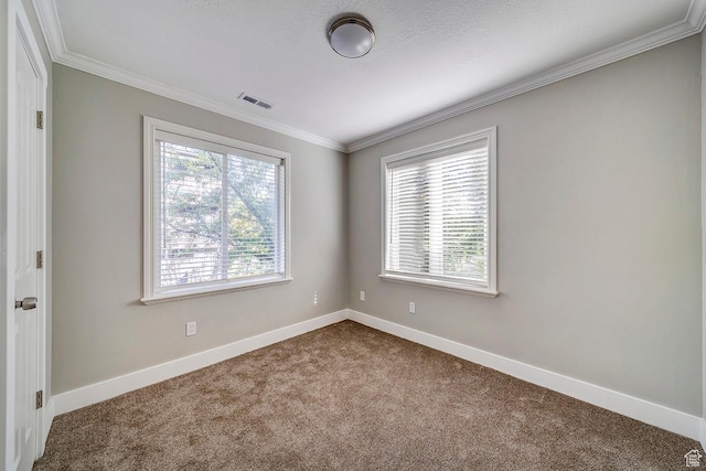 unfurnished room featuring dark colored carpet, crown molding, and baseboards