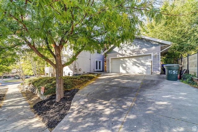 obstructed view of property featuring concrete driveway and a garage
