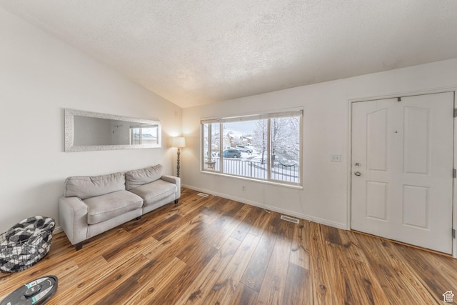1501 W 2060 S, Woods Cross, UT 84087 - living room with vaulted ceiling, wood-type flooring, a textured ceiling, and baseboards