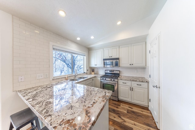 1501 W 2060 S, Woods Cross, UT 84087 - kitchen featuring stainless steel appliances, a sink, a peninsula, white cabinets, and vaulted ceiling