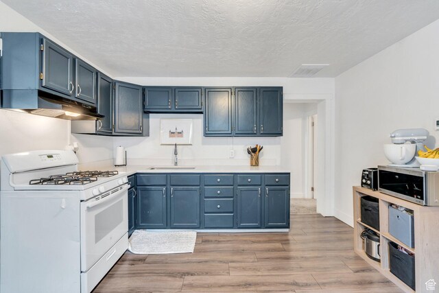 358 W 400 S, Provo, UT 84601 - kitchen with white gas range, a sink, under cabinet range hood, wood finished floors, and light countertops