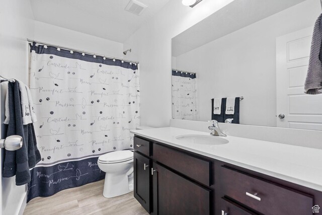 full bath with wood finished floors, toilet, vanity, and a shower with shower curtain
