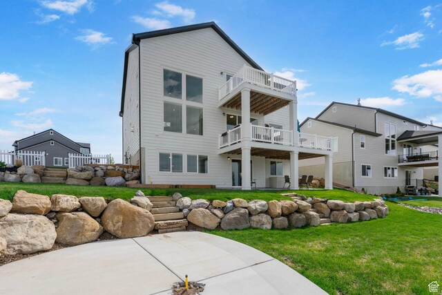 back of house featuring a balcony, a yard, and a patio area