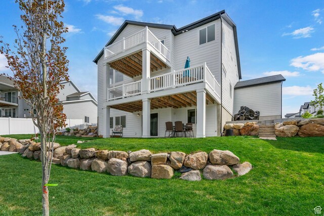 rear view of property featuring a balcony and a patio area
