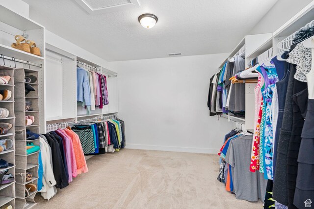 walk in closet featuring carpet flooring and attic access