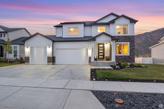view of front of house featuring board and batten siding, stone siding, and driveway