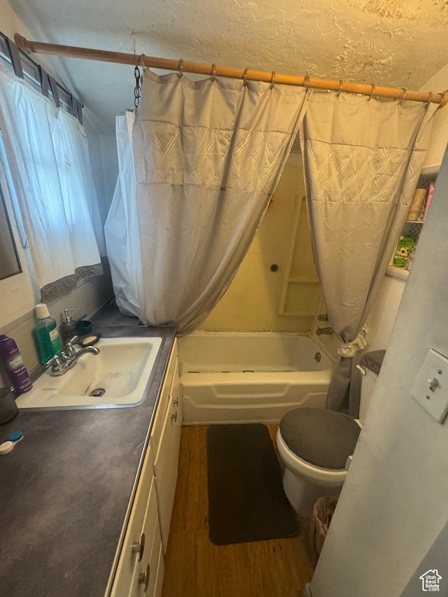 bathroom with toilet, vanity, shower / tub combo, and wood finished floors