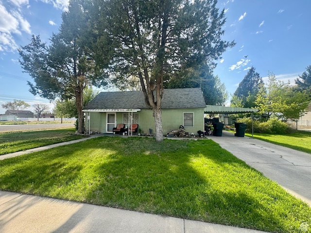 view of front of property with concrete driveway, a front yard, and an attached carport