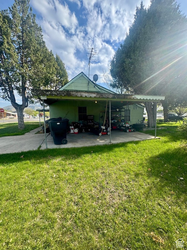 back of house with a yard, a patio area, and an attached carport