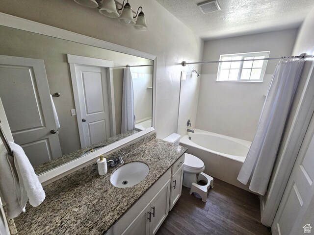 1771 E Skyline Dr Unit I4, Eagle Mountain, UT 84005 - bathroom featuring a textured ceiling, wood finished floors, toilet, shower / tub combo with curtain, and vanity