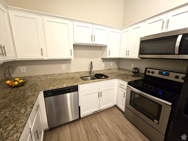 1771 E Skyline Dr Unit I4, Eagle Mountain, UT 84005 - kitchen featuring appliances with stainless steel finishes, a sink, white cabinetry, and light wood-style floors