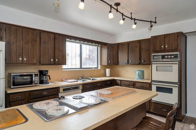 825 W Arapahoe Ave S, Salt Lake City, UT 84104 - kitchen with white appliances, a sink, dark brown cabinetry, and light countertops