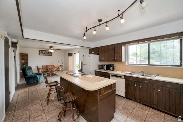 825 W Arapahoe Ave S, Salt Lake City, UT 84104 - kitchen with white appliances, a sink, a kitchen breakfast bar, dark brown cabinetry, and light countertops