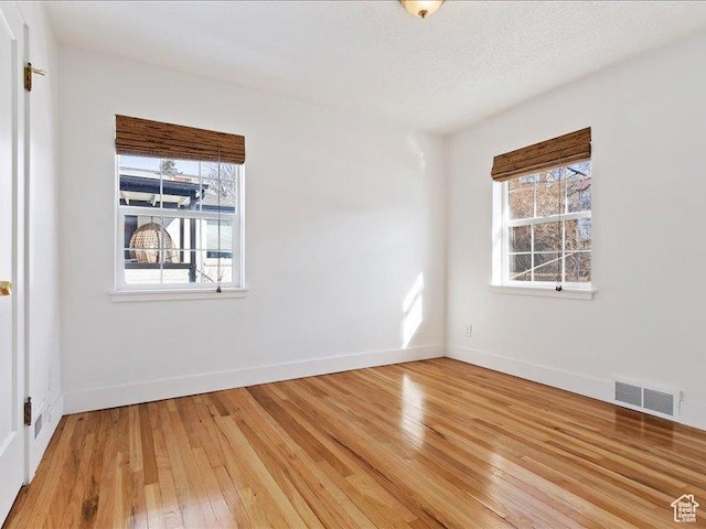 empty room featuring light wood-type flooring and baseboards