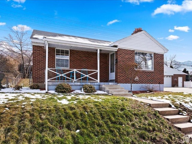 view of front of house featuring covered porch, brick siding, and a front yard