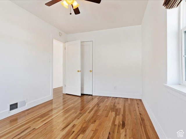 unfurnished bedroom featuring light wood-style floors, baseboards, and ceiling fan