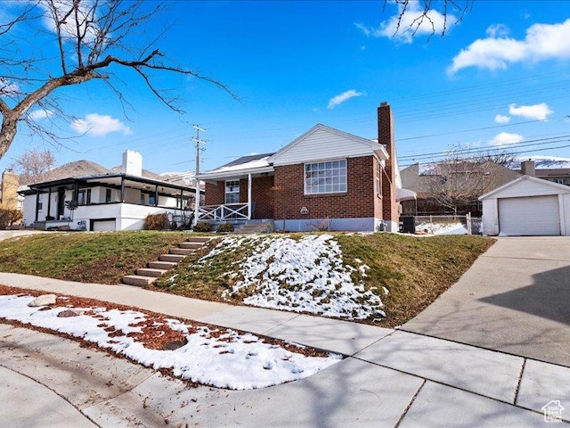 ranch-style house with brick siding, a chimney, concrete driveway, a garage, and covered porch