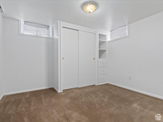 unfurnished bedroom featuring carpet, a closet, and baseboards