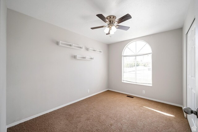 unfurnished bedroom featuring carpet, baseboards, a closet, and ceiling fan