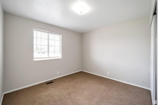 unfurnished room with carpet floors and baseboards