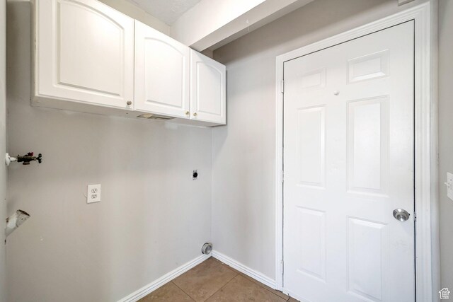 washroom with electric dryer hookup, baseboards, cabinet space, light tile patterned floors, and hookup for a washing machine