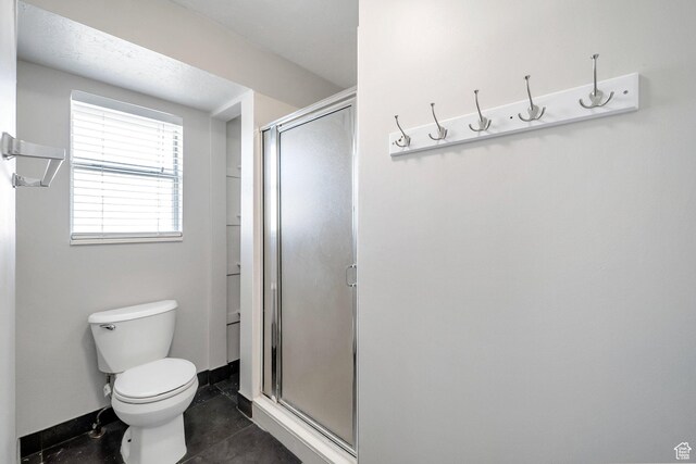 full bathroom featuring a stall shower and toilet