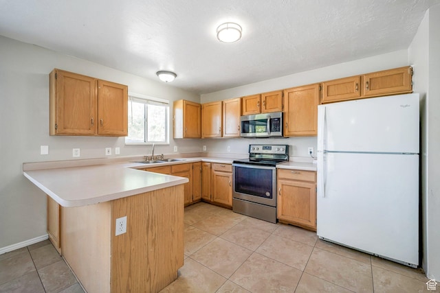 kitchen featuring stainless steel appliances, a sink, a peninsula, light countertops, and light tile patterned floors