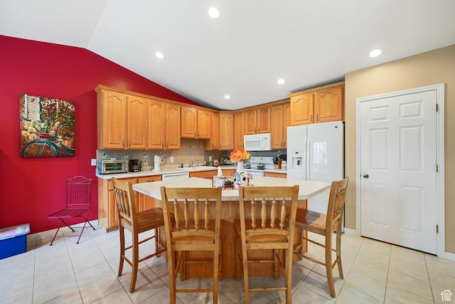 kitchen with white appliances, a sink, lofted ceiling, light countertops, and a kitchen island