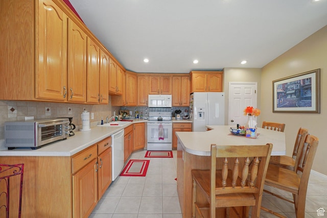 kitchen featuring white appliances, light tile patterned floors, backsplash, light countertops, and a sink