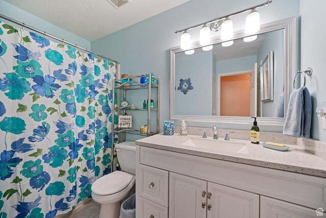 bathroom with toilet, vanity, and curtained shower